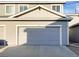 Attached gray garage with concrete driveway and the address number '104' at 6108 Kochia Ct # 104, Erie, CO 80516