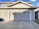 Attached gray garage with concrete driveway and the address number '104' at 6108 Kochia Ct # 104, Erie, CO 80516