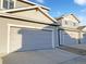 Multiple attached gray garages with concrete driveways and address numbers at 6108 Kochia Ct # 104, Erie, CO 80516