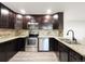 Stainless steel appliances with dark cabinets and stone backsplash that add to the kitchen's charm at 6108 Kochia Ct # 104, Erie, CO 80516