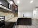 Modern kitchen featuring stainless steel appliances, granite countertops, and dark wood cabinetry at 6108 Kochia Ct # 104, Erie, CO 80516