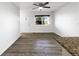 Open-concept living room with laminate flooring, window, and bright lighting at 6108 Kochia Ct # 104, Erie, CO 80516