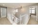 Bright hallway with carpet flooring, white staircase, and modern pendant lighting fixtures illuminating the space at 23201 E Orchard Pl, Aurora, CO 80015