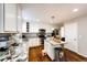 Well-lit kitchen features white cabinets, stainless steel appliances, granite countertops, and hardwood floors at 23201 E Orchard Pl, Aurora, CO 80015