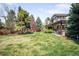 Spacious backyard with lush green grass, mature trees, and outdoor patio with outdoor seating at 1448 E Maplewood Ct, Centennial, CO 80121