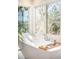 This bathroom features a soaking tub with a large window, creating a serene and relaxing ambiance at 1448 E Maplewood Ct, Centennial, CO 80121