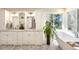 This bathroom features a soaking tub, a large window, and a dual sink vanity at 1448 E Maplewood Ct, Centennial, CO 80121