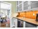 Stylish butler's pantry with custom cabinetry, a beverage fridge, and access to the dining room at 1448 E Maplewood Ct, Centennial, CO 80121