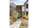 Inviting front entrance with a unique arched window above the door and stone pathway lined with landscaping at 1448 E Maplewood Ct, Centennial, CO 80121