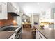 Bright kitchen features stainless steel appliances, stone countertops, and hardwood floors, blending style and functionality at 1448 E Maplewood Ct, Centennial, CO 80121