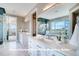 Elegant bathroom with double sinks, marble countertops, and a large window offering serene outdoor views at 1055 Greens Pl, Erie, CO 80516