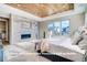 Relaxing bedroom showcasing a striking wood-paneled ceiling, fireplace, and a cozy bed near large view-framing windows at 1055 Greens Pl, Erie, CO 80516