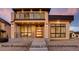 Craftsman style exterior with tan stucco, stone accents, dark trim, wood door, modern design, and concrete steps at 1055 Greens Pl, Erie, CO 80516