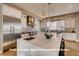 Bright kitchen featuring white cabinets, stainless steel appliances, and a large center island with seating at 1055 Greens Pl, Erie, CO 80516