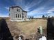 Backyard features a gray two-story home, stone accents, and partial-grass yard with trampoline at 914 Peach Leaf Ln, Elizabeth, CO 80107