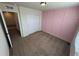 Cozy bedroom features neutral carpet, a pink accent wall, and a closet with sliding doors at 914 Peach Leaf Ln, Elizabeth, CO 80107