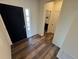 Entryway with wood-look flooring, a black door, and a view into a half bathroom at 914 Peach Leaf Ln, Elizabeth, CO 80107