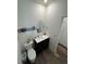Neat half bathroom featuring a dark vanity and round mirror, with wood-look flooring at 914 Peach Leaf Ln, Elizabeth, CO 80107