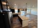 Open kitchen featuring a large island, dark cabinetry, granite counters, and stainless steel appliances at 914 Peach Leaf Ln, Elizabeth, CO 80107
