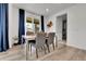 Well-lit dining room features stylish table set, modern decor, and sliding door with elegant blue curtains at 22472 E Narrowleaf Cir, Aurora, CO 80016