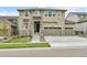 A two-story house with stone accents, a three-car garage, and a well-maintained lawn on a sunny day at 22472 E Narrowleaf Cir, Aurora, CO 80016