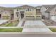 Two-story home with a three-car garage, stone accents, and concrete driveway in a residential neighborhood at 22472 E Narrowleaf Cir, Aurora, CO 80016