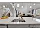 Open-concept kitchen with a large island, stainless steel sink, and adjacent living area with fireplace at 22472 E Narrowleaf Cir, Aurora, CO 80016