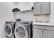 This laundry room features gray washer and dryer, sink, countertop and cabinets at 22472 E Narrowleaf Cir, Aurora, CO 80016