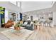 Bright, open-concept living room connected to the kitchen, featuring modern furniture and hardwood flooring at 22472 E Narrowleaf Cir, Aurora, CO 80016