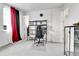 A well-lit office space with a comfortable gaming chair, storage shelving, and a view towards another room at 22472 E Narrowleaf Cir, Aurora, CO 80016