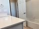 Bright bathroom features a white vanity with quartz countertop and white tiled shower with a tub at 17170 E 90Th Pl, Commerce City, CO 80022