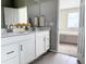 Bright bathroom featuring a double vanity with white cabinets and view to bedroom at 17170 E 90Th Pl, Commerce City, CO 80022