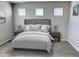 Staged bedroom with a bed, two side tables, three windows, and carpeted floors at 17170 E 90Th Pl, Commerce City, CO 80022