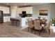 Open-concept kitchen and dining area with wood floors and modern white cabinets at 17170 E 90Th Pl, Commerce City, CO 80022