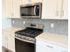 Modern stainless steel stove and gray backsplash at 17170 E 90Th Pl, Commerce City, CO 80022