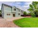 The backyard is a mix of green grass, a concrete patio and a stone area. The house is painted light blue at 15828 Greenstone Ln, Parker, CO 80134