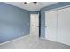 Blue bedroom featuring white closets, a ceiling fan, and a doorway to another room at 15828 Greenstone Ln, Parker, CO 80134