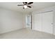 Bedroom featuring a ceiling fan, an open doorway, and white closets at 15828 Greenstone Ln, Parker, CO 80134