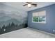 Blue bedroom featuring gray mountain mural, a ceiling fan, and a window with blinds at 15828 Greenstone Ln, Parker, CO 80134