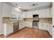 Well-lit kitchen features white cabinets, stainless steel appliances, tile backsplash and granite countertops at 15828 Greenstone Ln, Parker, CO 80134