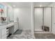 Bathroom with double vanity, framed mirrors, tiled shower with glass door, and built-in seat at 24326 E Ohio Dr, Aurora, CO 80018