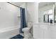 Modern bathroom with a bathtub, toilet, vanity with a mirror, white tiling, and blue accents, creating a clean and serene space at 24326 E Ohio Dr, Aurora, CO 80018