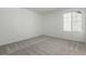 Bedroom with neutral carpeting, a bright window, and ample open space, offering a cozy and versatile environment at 24326 E Ohio Dr, Aurora, CO 80018