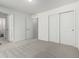 Bright bedroom featuring neutral carpet, double door closets, and access to the en suite bathroom, providing ample space and comfort at 24326 E Ohio Dr, Aurora, CO 80018