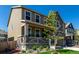 Attractive two-story home with a stone facade, covered porch, and a lush, green front lawn at 24326 E Ohio Dr, Aurora, CO 80018