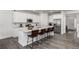 Modern kitchen featuring white cabinetry, stainless steel appliances, a large island, and wood-look floors at 24326 E Ohio Dr, Aurora, CO 80018