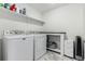 Practical laundry room with modern washing machine and dryer, storage shelf, and functional countertop, offering efficiency and utility at 24326 E Ohio Dr, Aurora, CO 80018