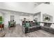Open concept living room with wood floors, a large grey sectional, and an open flow to dining and kitchen at 24326 E Ohio Dr, Aurora, CO 80018