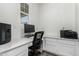 Cozy office features a built-in desk with white cabinets, a black office chair, and a window at 24326 E Ohio Dr, Aurora, CO 80018