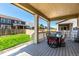 Cozy outdoor patio featuring a dining table with chairs, a rocking chair, and a serene view of the manicured lawn at 24326 E Ohio Dr, Aurora, CO 80018